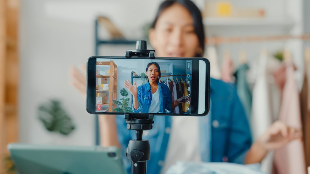 an image of a woman creating a video for her store, showing the idea of influencer marketing, and important 2025 marketing trend