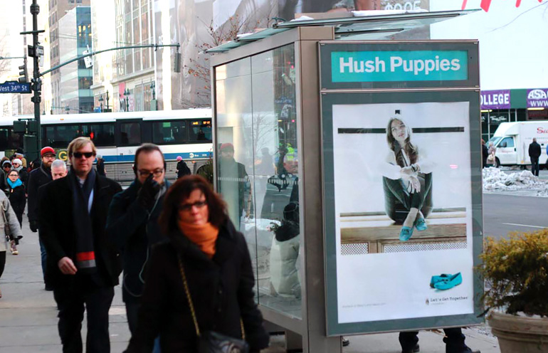 Image of a transit shelter ad in an urban setting used to promote a retail apparel brand