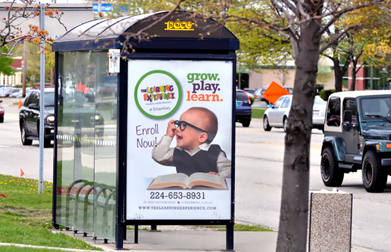 Image of bus shelter ad in a suburban environment for an education advertiser