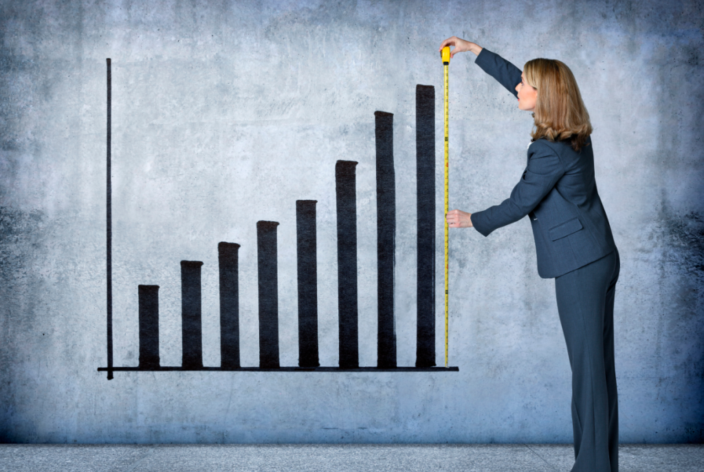 Woman standing over bar chart on wall